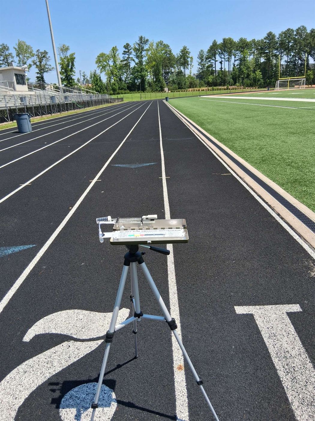 Standard WBGT Kit with slide rule calculator set up on a running track